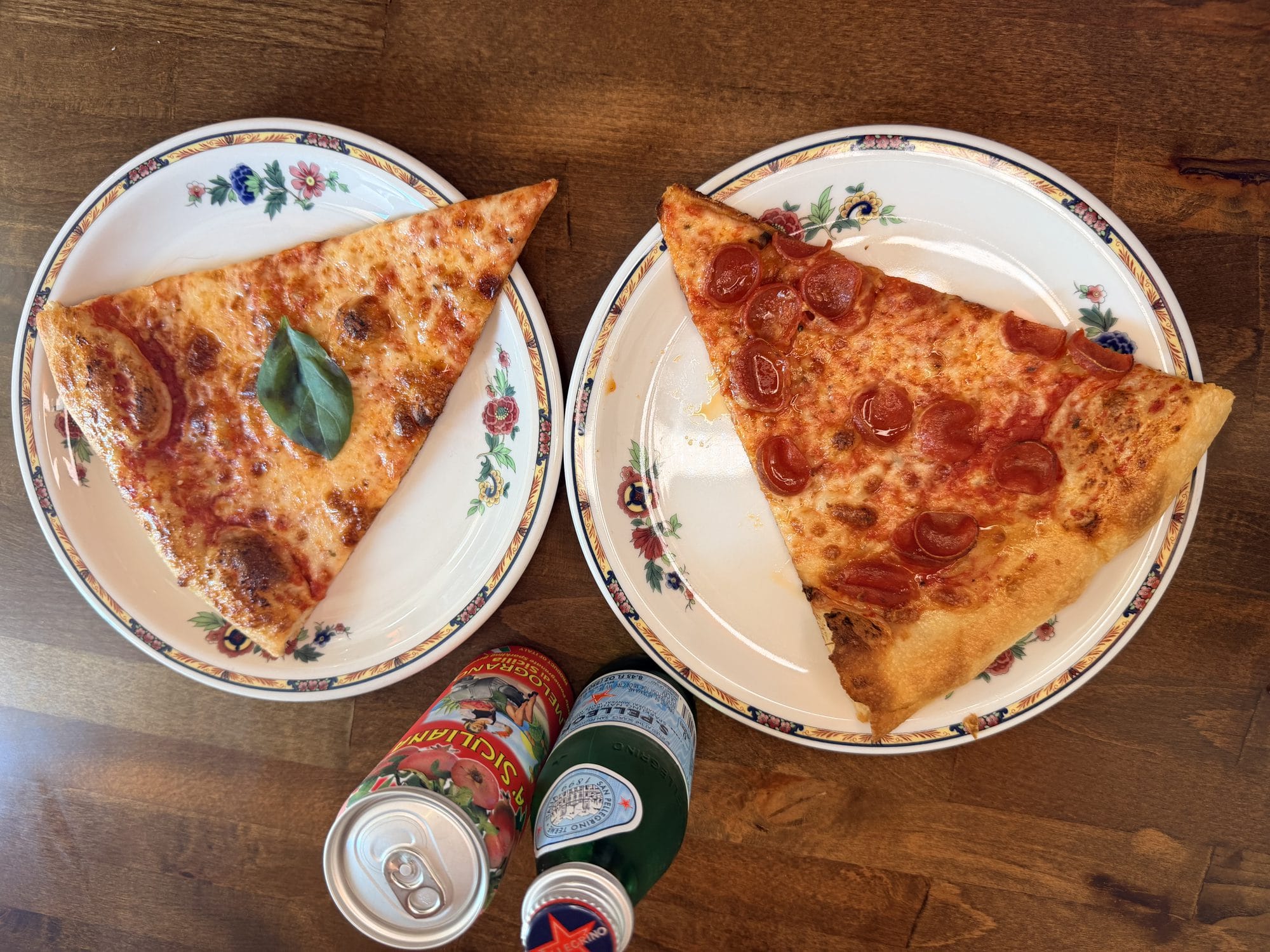 Two slices — margherita and pepperoni — on floral plates